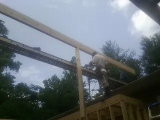 Carpenter setting a ridge beam over a new addition frame — Ice Dam Removal by Roofing Brothers in Sargent