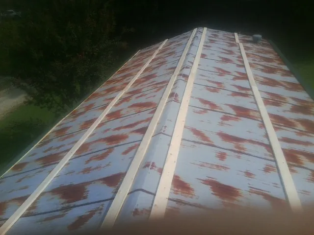 Rusted metal roof panels with new wood purlins before replacement — Storm Damage Roof Repair in Sargent by Roofing Brothers