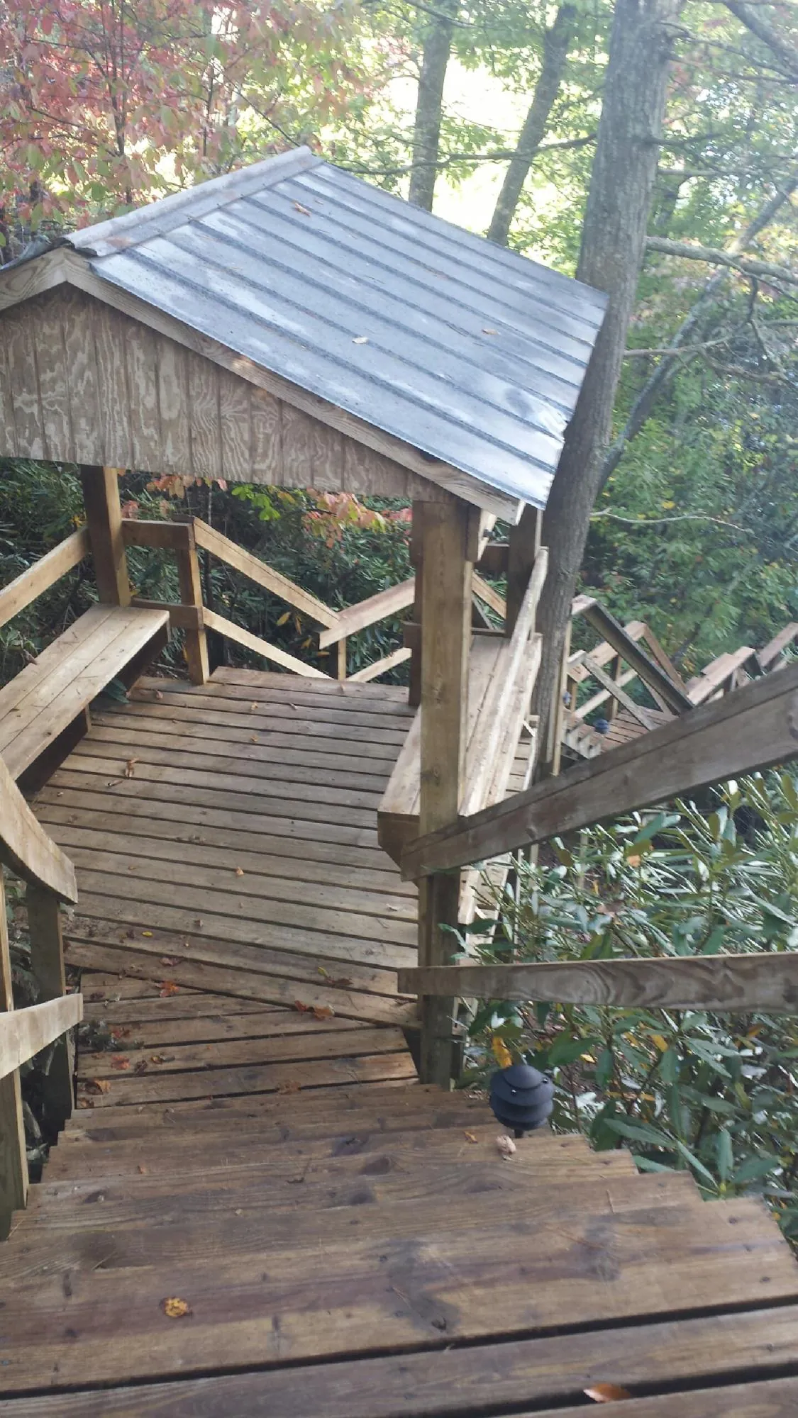 Metal roofed shelter over wooden steps on a wooded walkway — Skylight Repair & Installation work by our crew in Sargent