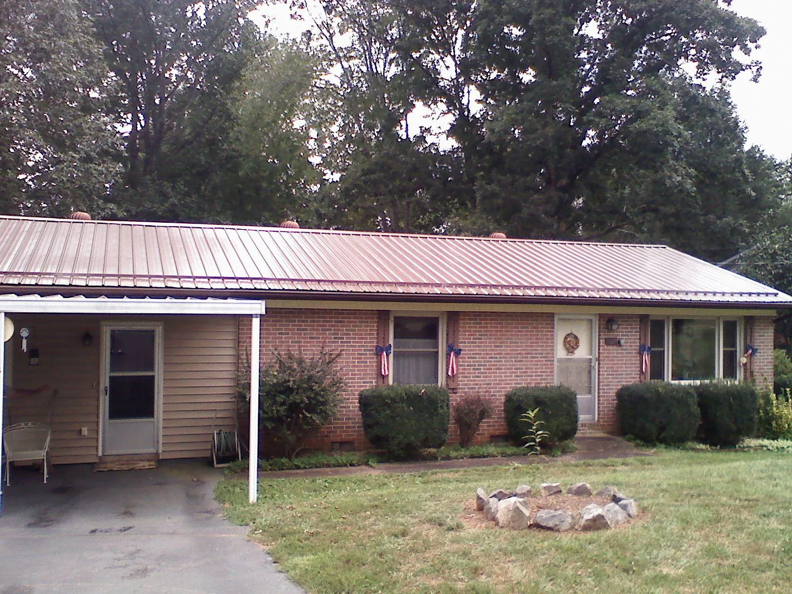 Bronze metal roof and carport on a brick ranch home — Roof Repair work by our crew in Sargent